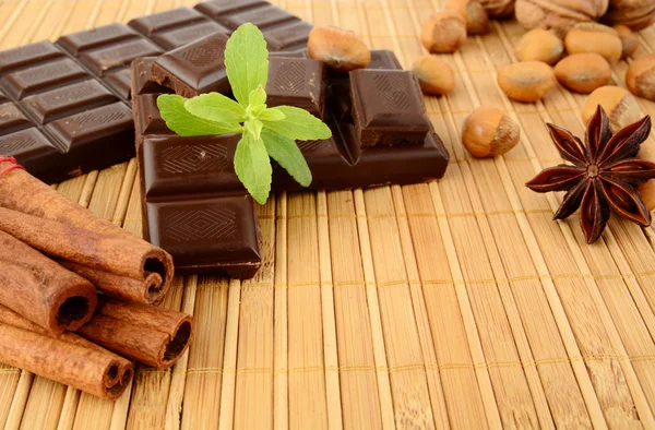 Set of chocolate,anise and cinnamon with sage on wooden mat — Stock Photo, Image