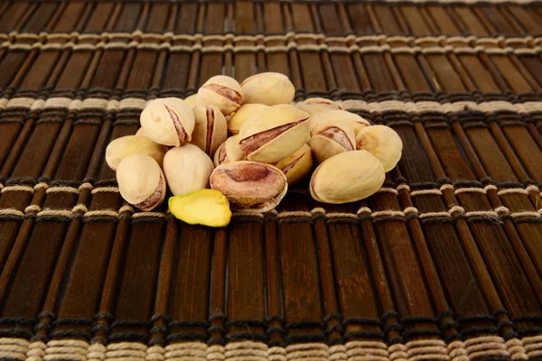 Many pistachios on brown mat — Stock Photo, Image