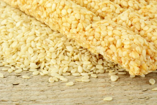 Sesame seeds scattered on wooden mat in the corner — Stock Photo, Image