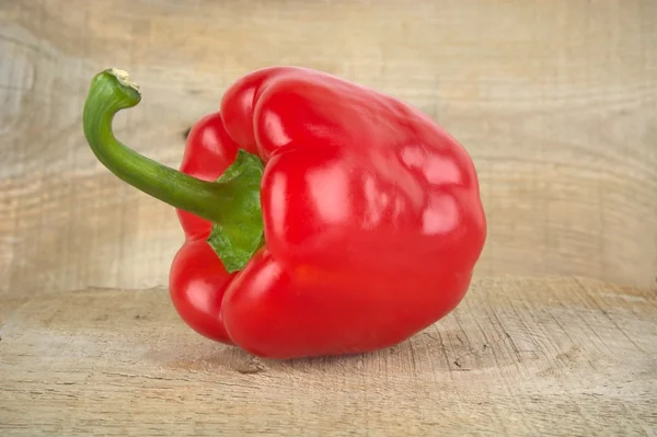 Studio shot of red bell pepper isolated on wooden board — Stock Photo, Image