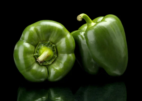 Studio skud af grønne peberfrugter isoleret på sort - Stock-foto