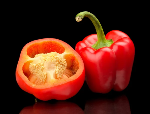 Closeup halved red bell peppers isolated on black — Stock Photo, Image