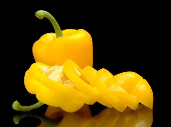 Closeup slices of yellow bell peppers on black with drops of wat — Stock Photo, Image