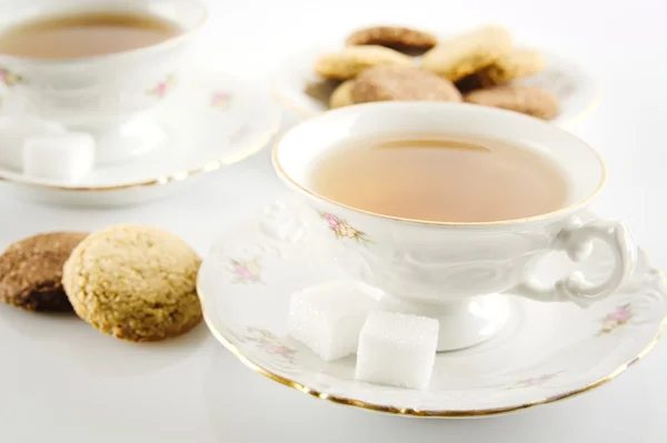 Altmodische Tasse Tee mit Keksen auf Weiß — Stockfoto