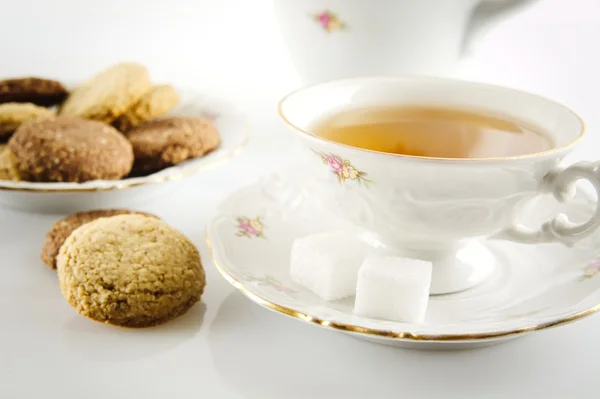 Old-style shot kettle with cup of tea with cookies foreground on — Stock Photo, Image