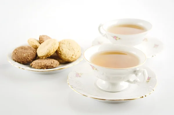 Csésze tea, a cookie-kat a fehér régi stílusú lövés — Stock Fotó