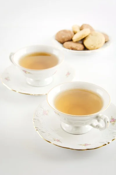 Old-style shot of cup of tea with cookies on white — Stock Photo, Image