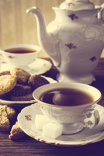 Old-fashioned image with two cups of tea vintage effect with cookies — Stock Photo, Image