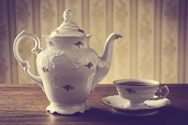 Old-fashioned vintage jug with tea with wallpaper background — Stock Photo, Image