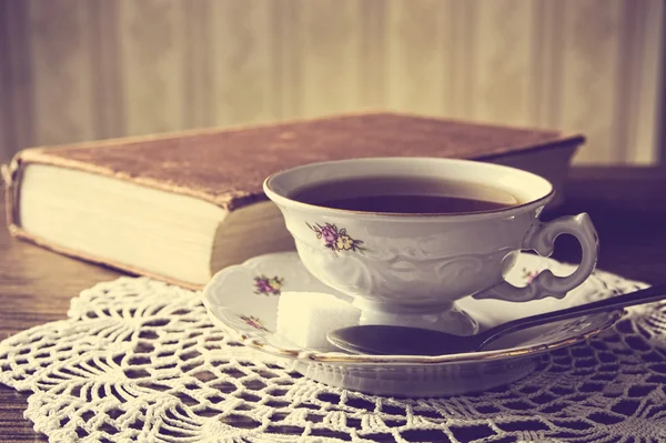 Cup of tea with book on napkin vintage effect — Stock Photo, Image