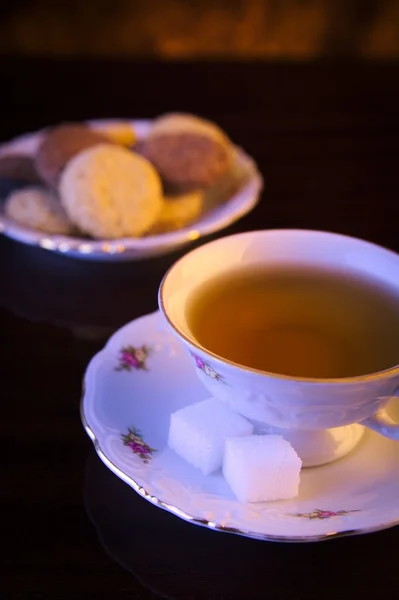 Old-style image cup of tea with cookies on black — Stock Photo, Image