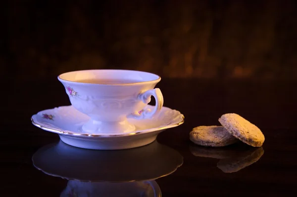 Old-style image cup of tea with cookies on black — Stock Photo, Image