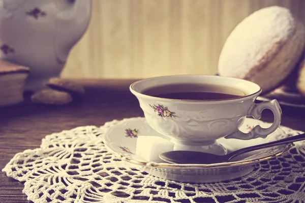 ナプキンの昔ながらの部屋で紅茶のカップとドーナツ — ストック写真