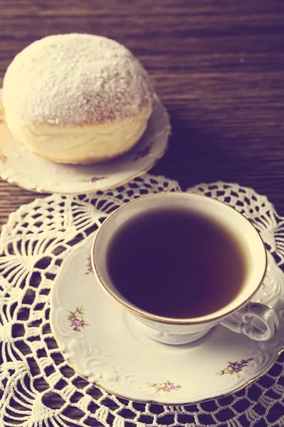 Beignet avec tasse de thé dans une pièce à l'ancienne sur une serviette — Photo