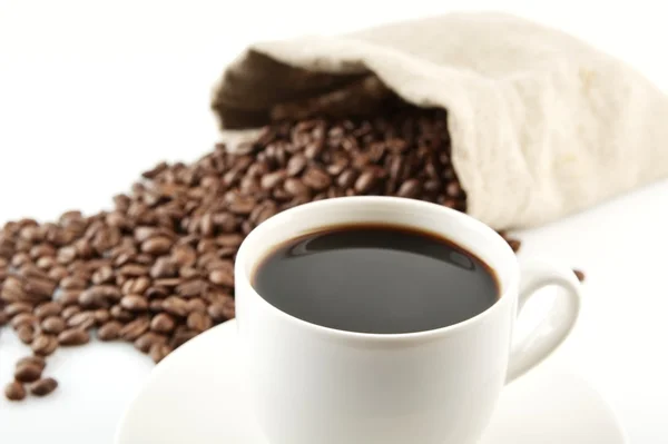 Kopje koffie met schotel met zak met koffiebonen op wit — Stockfoto
