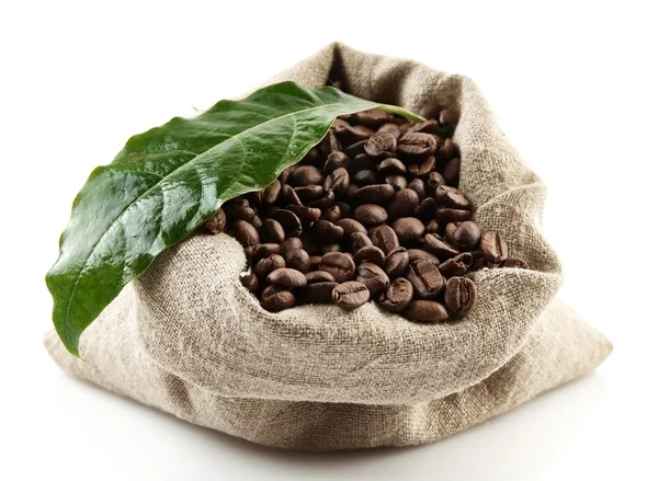 Saco cheio de grãos de café em branco com folha verde — Fotografia de Stock