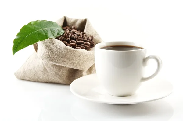 Sack full of coffee beans with green leaf and coffee cup — Stock Photo, Image