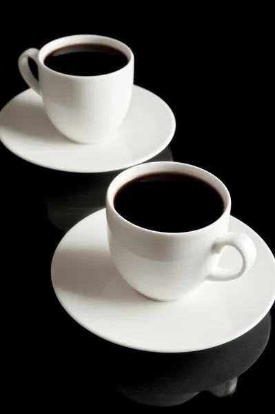 Cups of coffee with saucer isolated on black — Stock Photo, Image