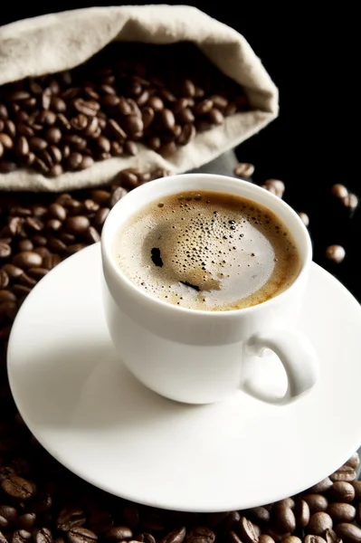Macro koffie met schuim en zak bij het ontbijt op zwarte achtergrond — Stockfoto