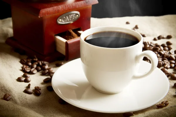 Long shot van een kop van koffie, zak, koffiebonen op vlas linnen — Stockfoto