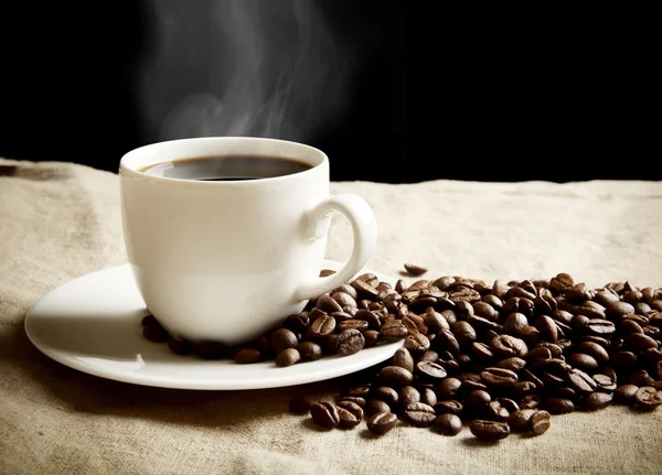Xícara de café com espuma com grãos em linho de tecido — Fotografia de Stock