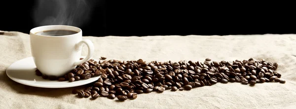 Panoramic view of frothy coffee cup with beans on fabric flax — Stock Photo, Image