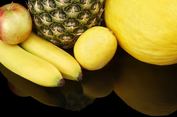 Набор желтых фруктов-ананас, цитрусовые, бананы на черном внизу — стоковое фото