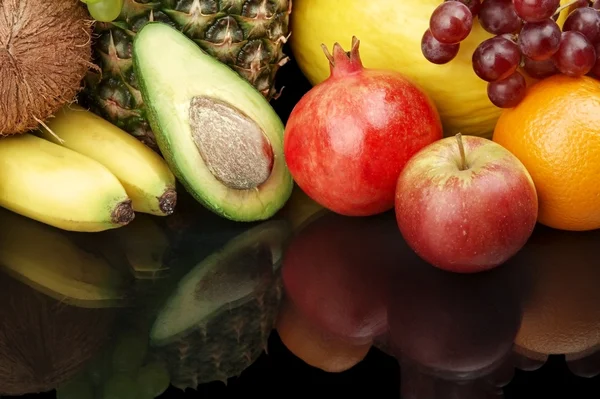 Bijgesneden shot van fruit-druiven, granaatappel, avocado op zwart met reflectie — Stockfoto