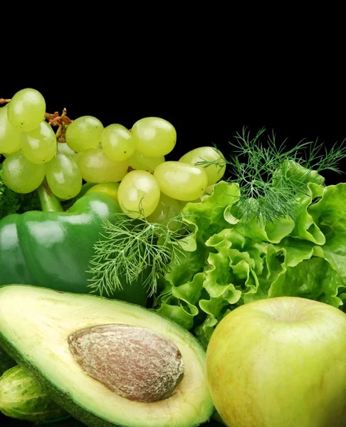Gruppe von grünem Gemüse und Obst auf schwarzem Grund Stockbild