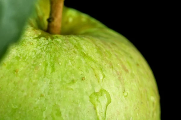 Macro closeup shot of drizzled green apple on black — Stock Photo, Image