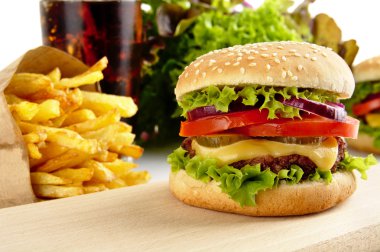 Çizburger, kızarmış patates, bardak kola ahşap üzerine resim kırpılmış