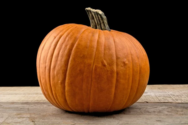 Primer plano de calabaza naranja sobre tabla sobre fondo negro —  Fotos de Stock