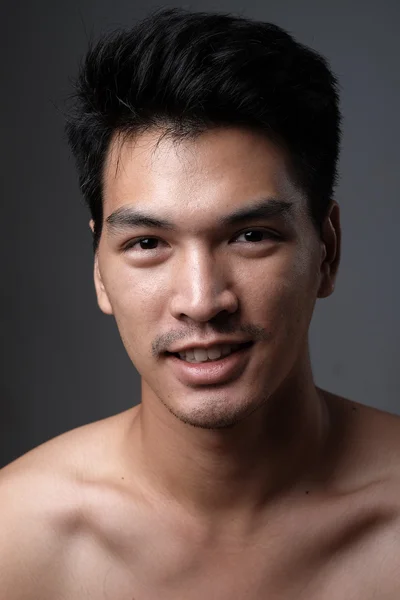 Retrato de hombre asiático sin maquillaje muestra su piel real en fondo gris - enfoque suave — Foto de Stock