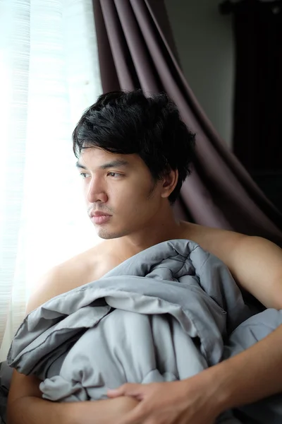 Un asiático sin camisa se despierta en la cama con manta - Soft Focus — Foto de Stock