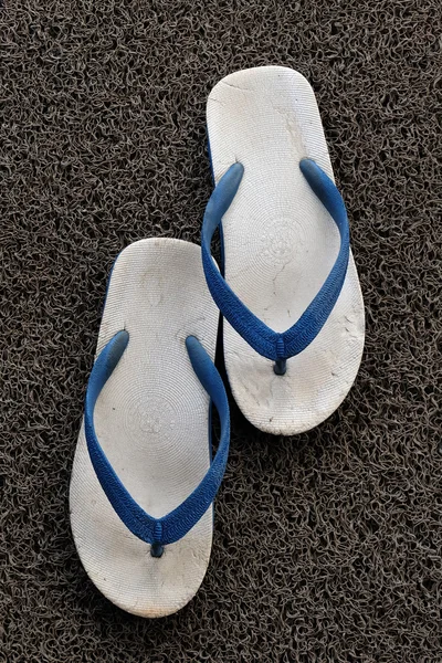Old sandals on the grey carpet — Stock Photo, Image