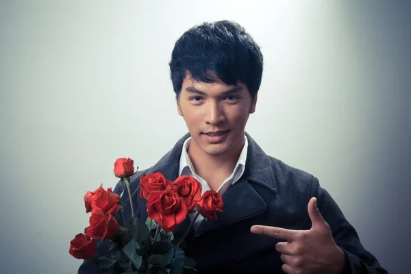 Asian guy with red roses in retro style — Stock Photo, Image