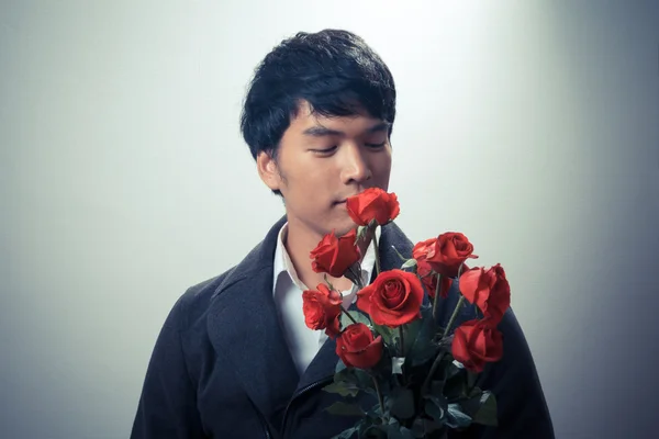 Asian guy with red roses in retro style — Stock Photo, Image