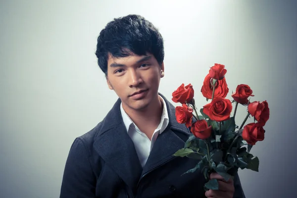 Asian guy with red roses in retro style — Stock Photo, Image