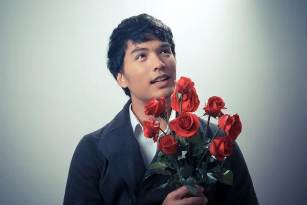 Asian guy with red roses in retro style — Stock Photo, Image