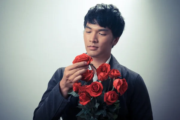 Asian guy with red roses in retro style — Stock Photo, Image