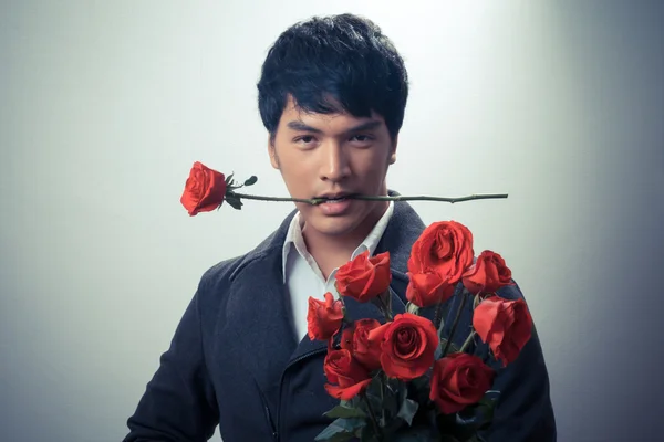 Asian guy with red roses in retro style — Stock Photo, Image