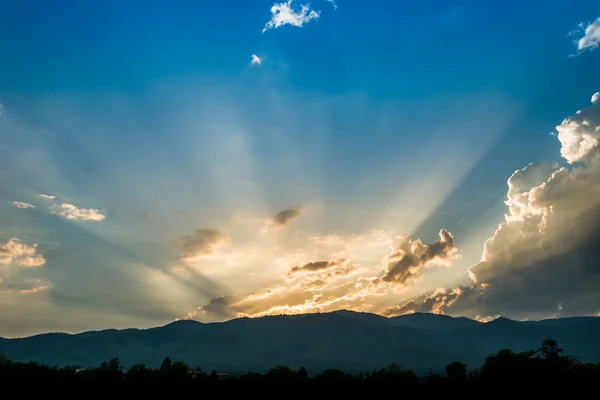 Tramonto dietro la montagna con un bel raggio di sole attraverso la nuvola — Foto Stock