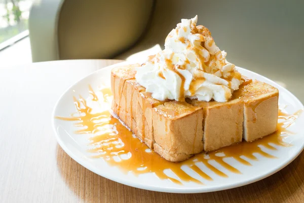 Golden honey toast in the white dish with whipped cream on top — ストック写真