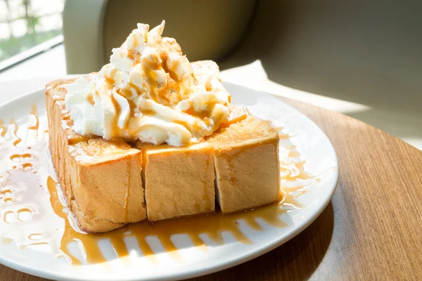 Golden honey toast in the white dish with whipped cream on top — ストック写真