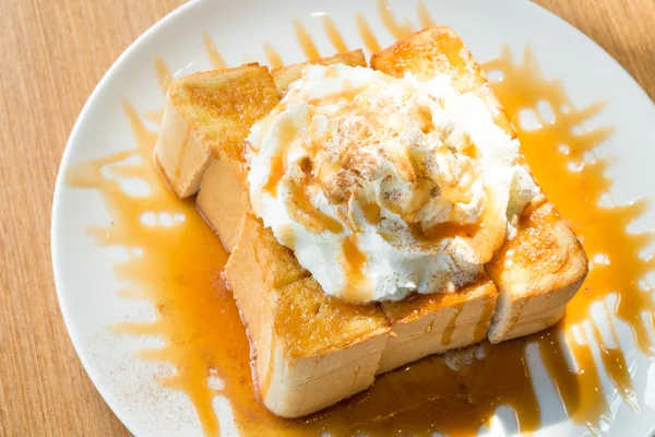Golden honey toast in the white dish with whipped cream on top — Stock Photo, Image