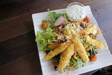 Tempura üstünde belgili tanımlık tepe ile taze sebze salatası