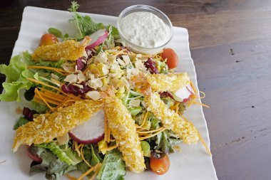 Tempura üstünde belgili tanımlık tepe ile taze sebze salatası