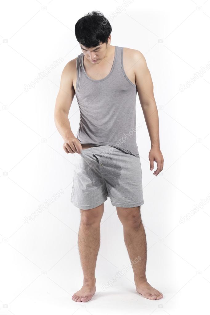 Asian man in grey pajamas with wet crotch