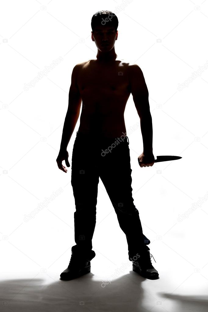 silhouette of a man holding knife