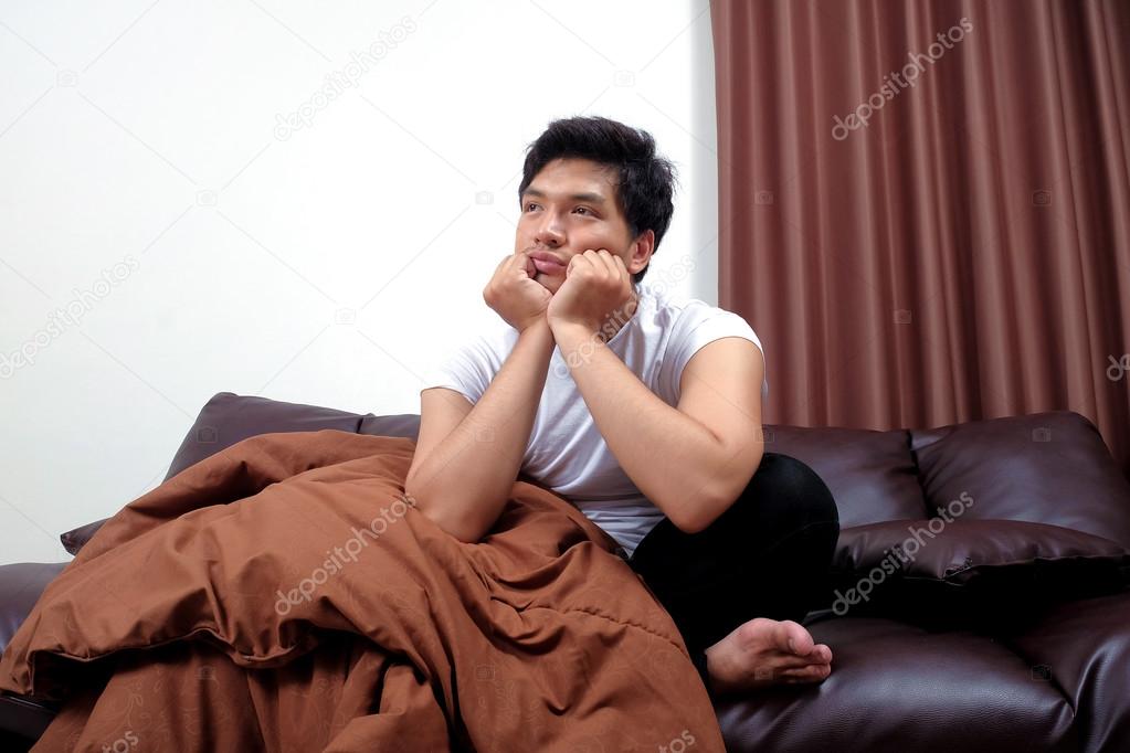 Asian man on the sofa with bored mood